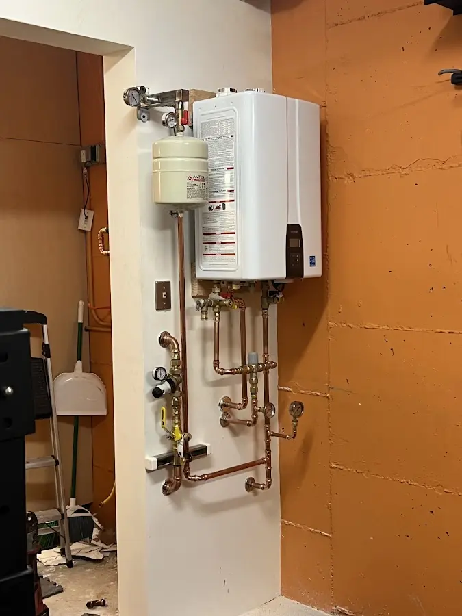 Plumbing technician inspecting water heater connections in Briar